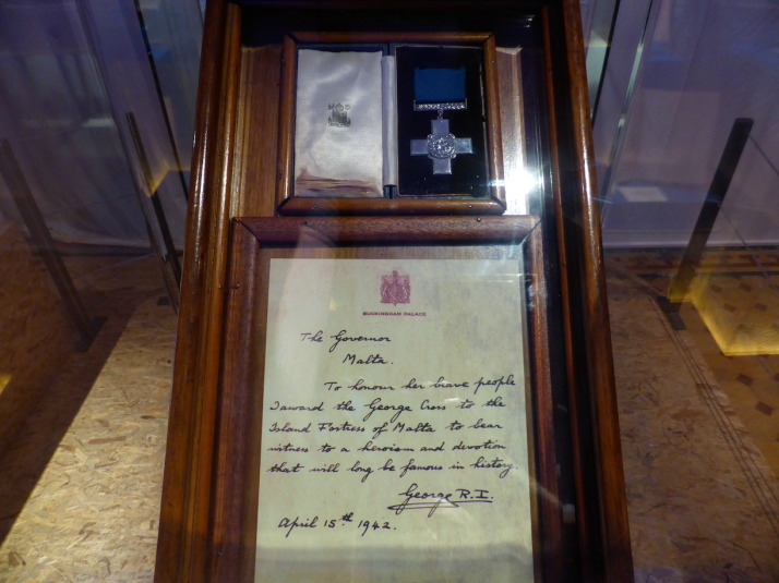 The George Cross for Gallantry awarded to the people of Malta and which adorns the nation's flag. The accompanying letter reads: "The Governor, Malta. To honour her brave people I award the George Cross to the Island Fortress of Malta to bear witness to a heroism and devotion that will long be famous in history. George R.I. April 15th 1942"