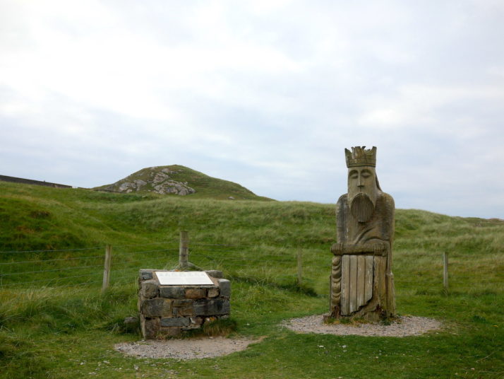 Large wood carving of the King piece from the Uig Chessmen chess set, and explanation board